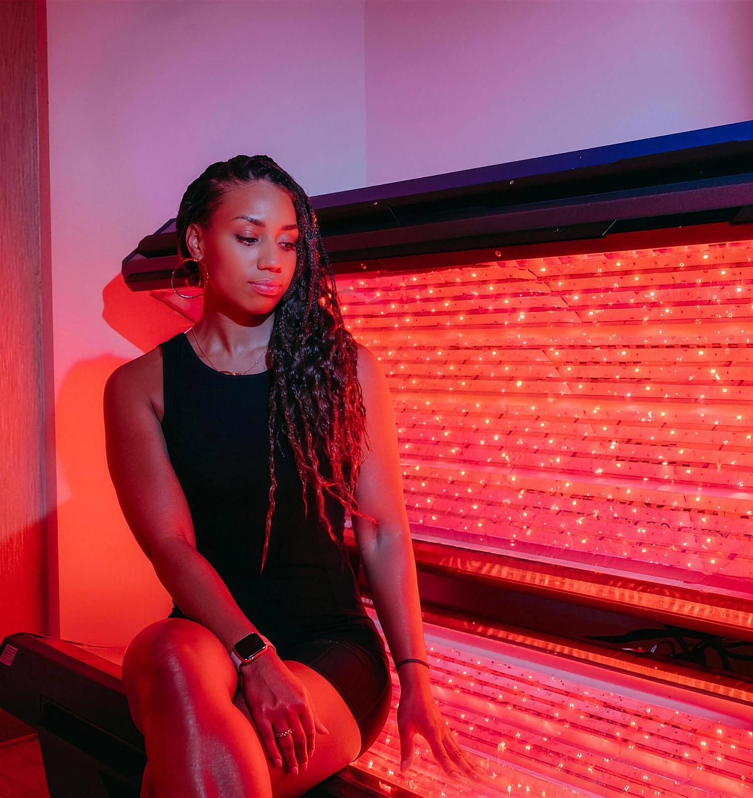 A member seated beside a therapeutic red light panel during a session at Citrin Longevity in West Hollywood, Los Angeles